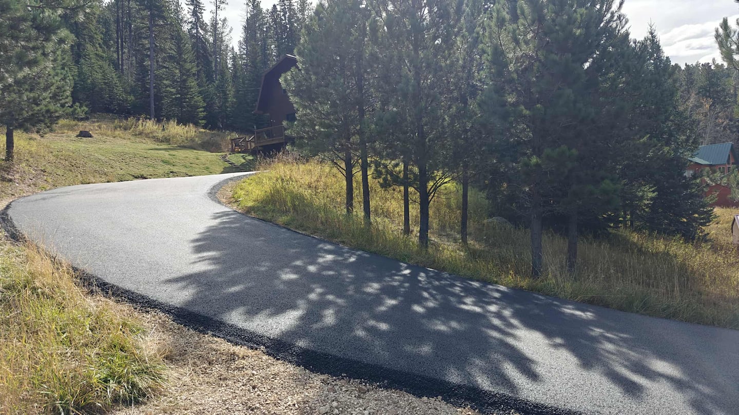Paved driveway winding through the property toward the cabin